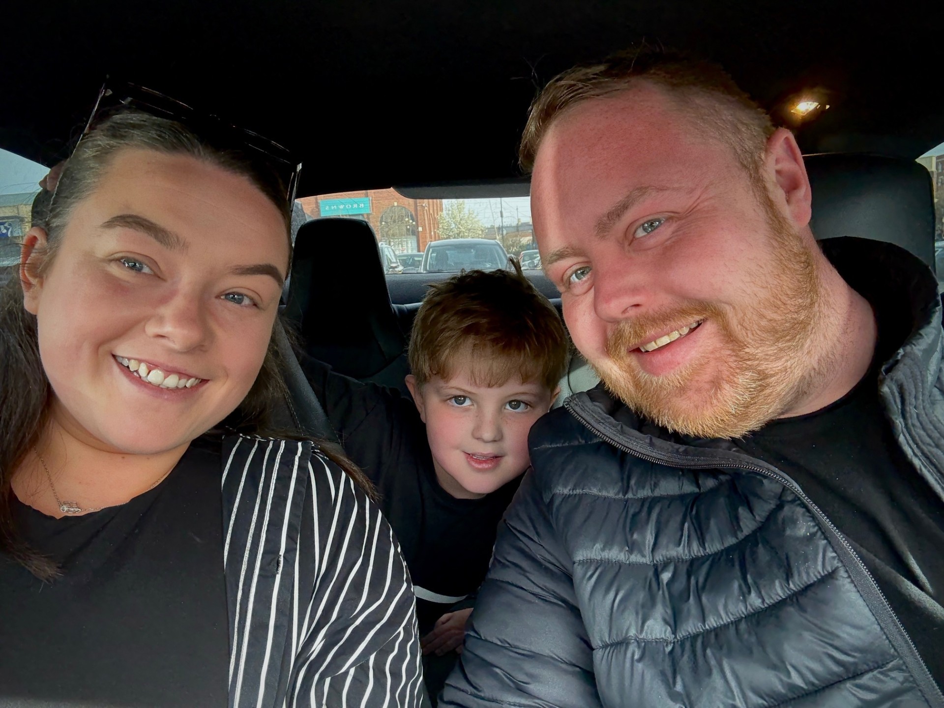 Alisha, James and Henry smiling together in the car